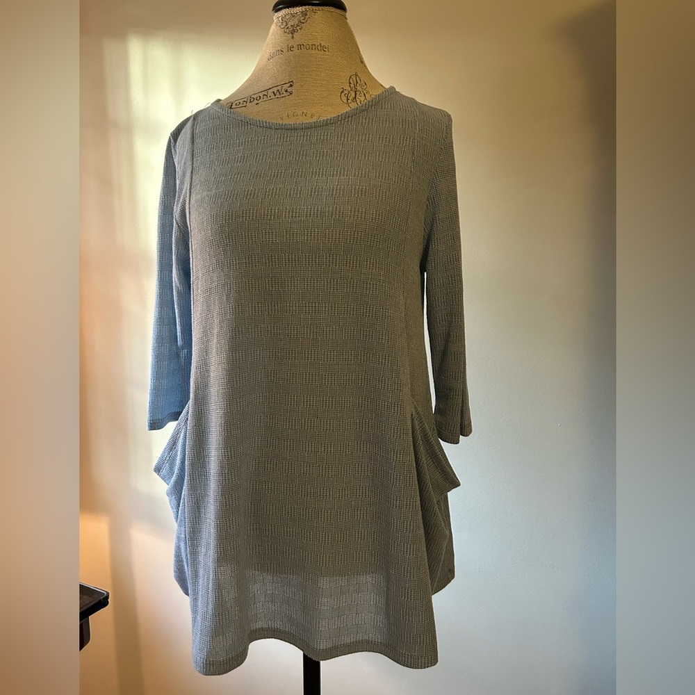 NWOT. Women’s size medium, flowy/stretchy tunic. Light blue, never worn